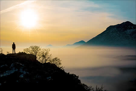 man looking at sunrise